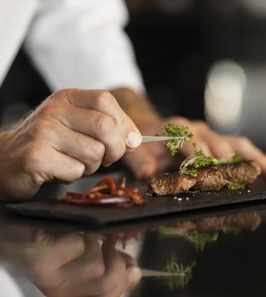 Chef montando prato de carne com ervas