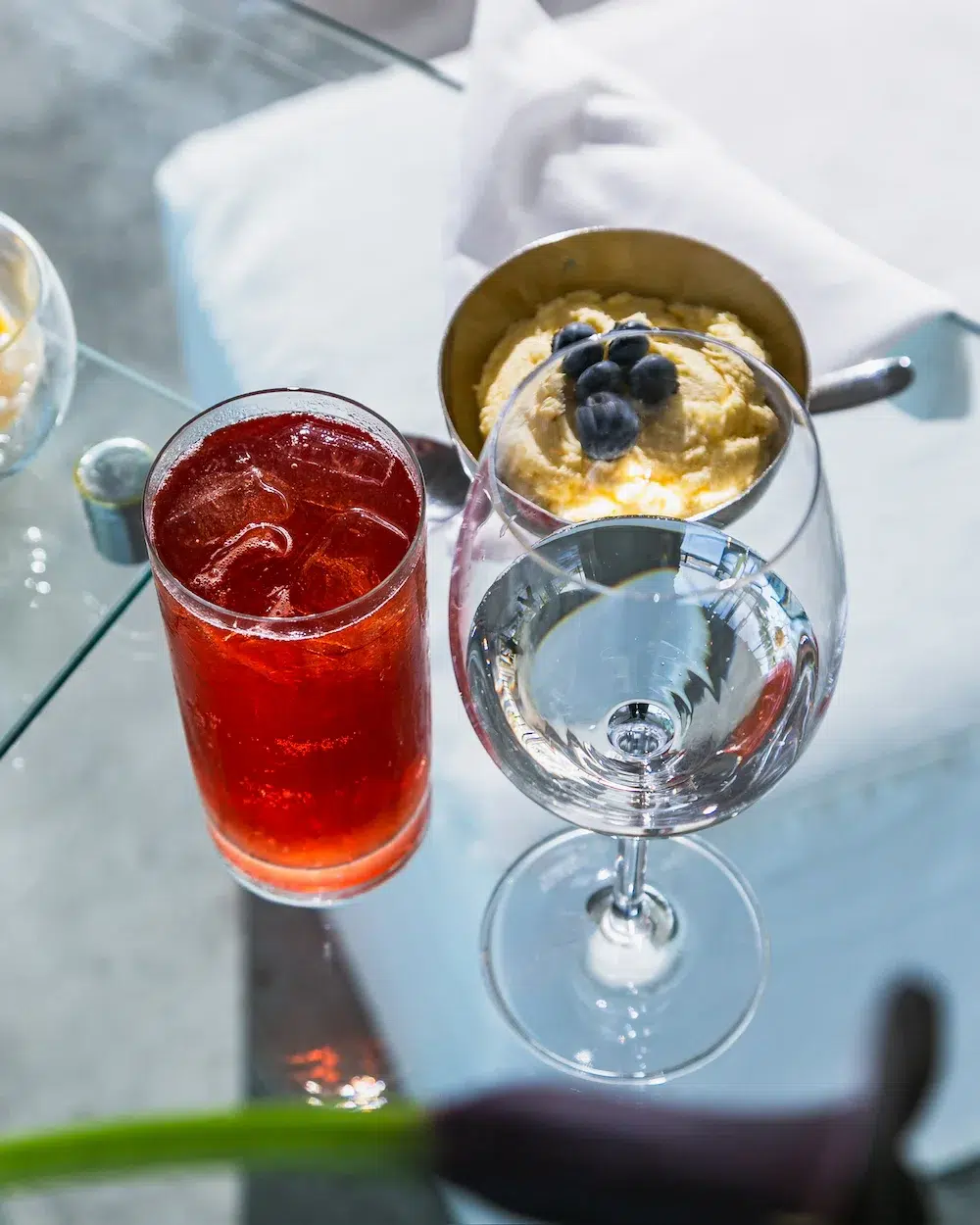 Drinks e taças sobre mesa de vidro