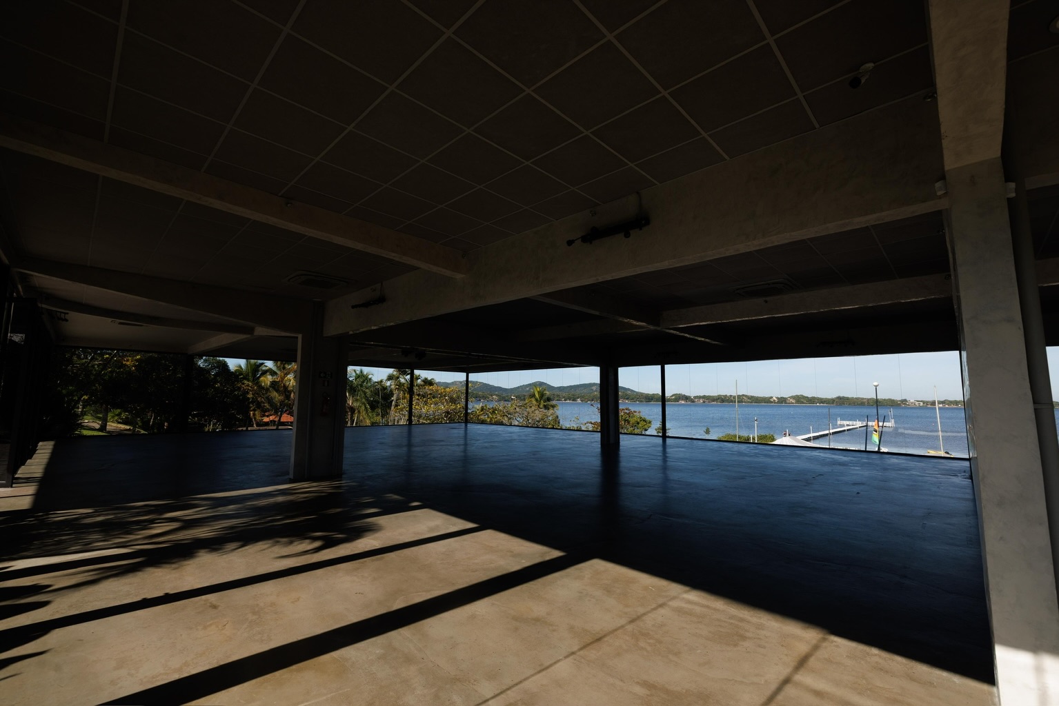 Salão do Panorama com paredes de vidro e vista para a lagoa